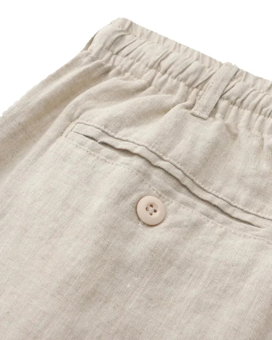 Back pocket with button on beige linen shorts