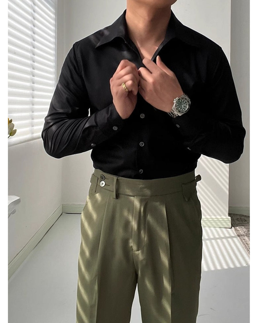 Zwart slim-fit overhemd gedragen met een olijfgroene broek, handen aan de kraag