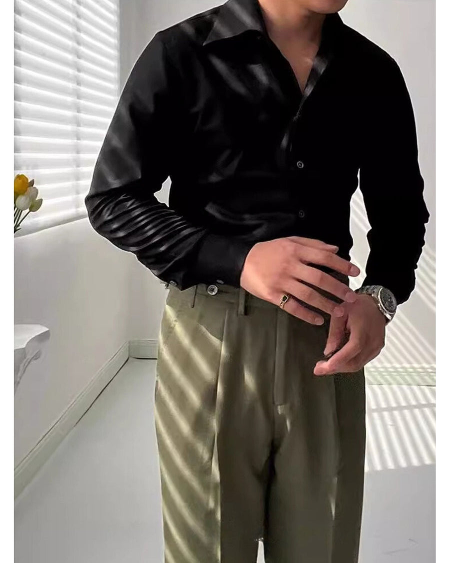Zwart slim-fit overhemd gedragen met een olijfgroene broek, gekruiste armen